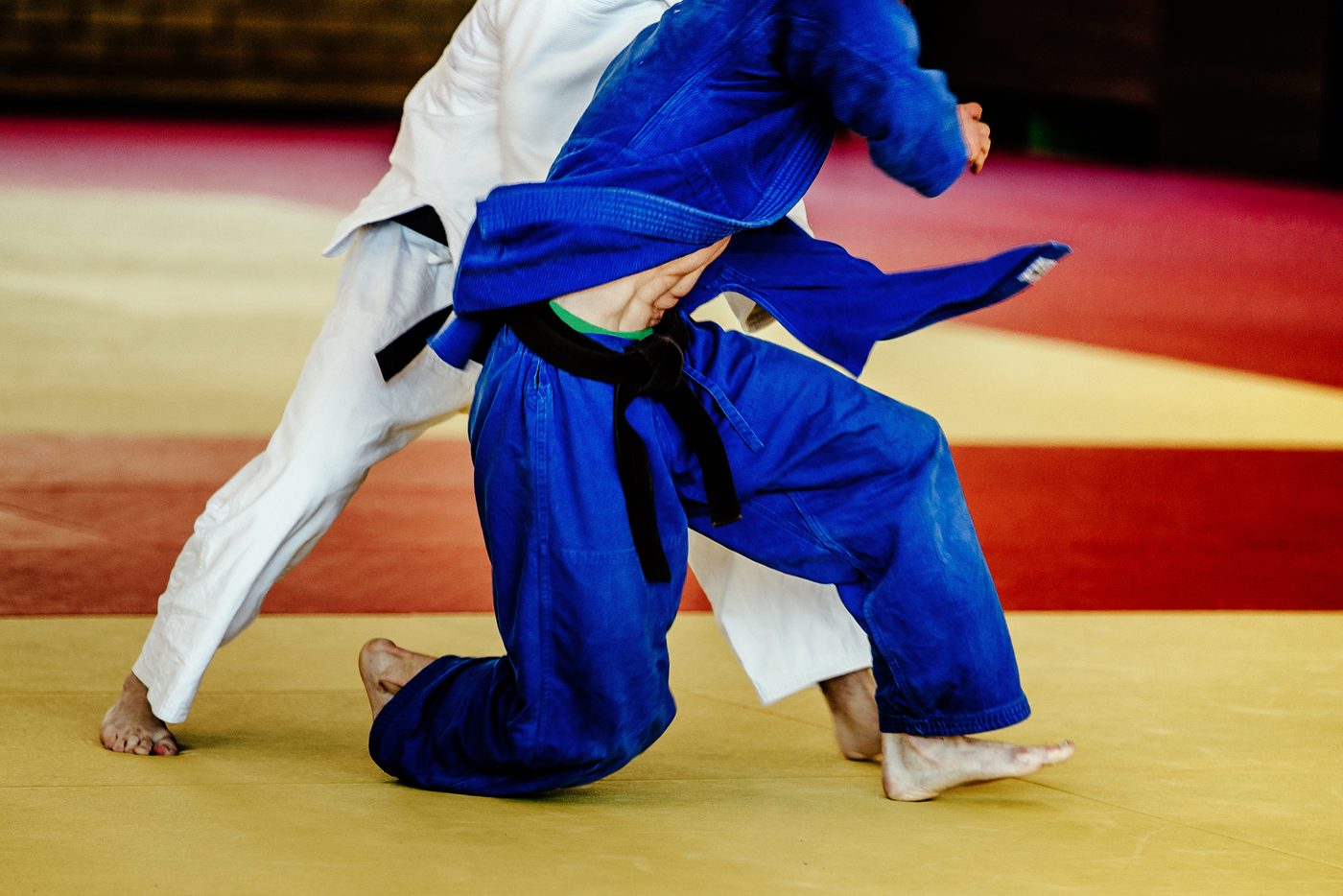 Two judoka gripping for a throw on a competition mat